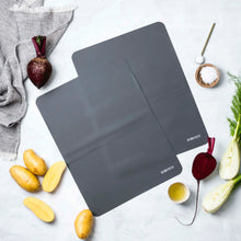 Load image into Gallery viewer, Two gray cutting boards on a white surface with vegetables around them - baking trays that are reusable
