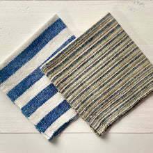Load image into Gallery viewer, Two striped rugs, one blue and white, the other brown and beige, on a light wooden floor.