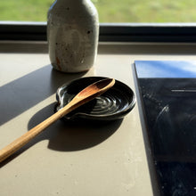 Load image into Gallery viewer, Ceramic bottle, wooden spoon, and black dish on a table with a window in the background