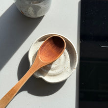 Load image into Gallery viewer, Wooden spoon on a ceramic dish with a speckled gray bottle in the background