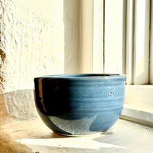 Load image into Gallery viewer, Blue ceramic bowl on a windowsill with sunlight casting shadows