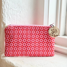 Load image into Gallery viewer, Red floral-patterned pouch with a gold tag on a light surface.
