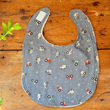 Load image into Gallery viewer, Gray bib with vehicle pattern on a wooden surface