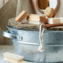 Load image into Gallery viewer, Bath brush, scrubber, and soap on a metal tub with a towel and mirror in the background.