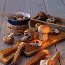 Load image into Gallery viewer, Mushrooms on a wooden surface with a frying pan and wooden utensils.