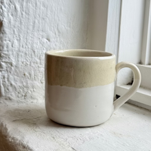 Load image into Gallery viewer, Ceramic mug with two-tone design on a windowsill
