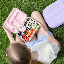 Load image into Gallery viewer, Child holding a pink bento box with a variety of food on grass
