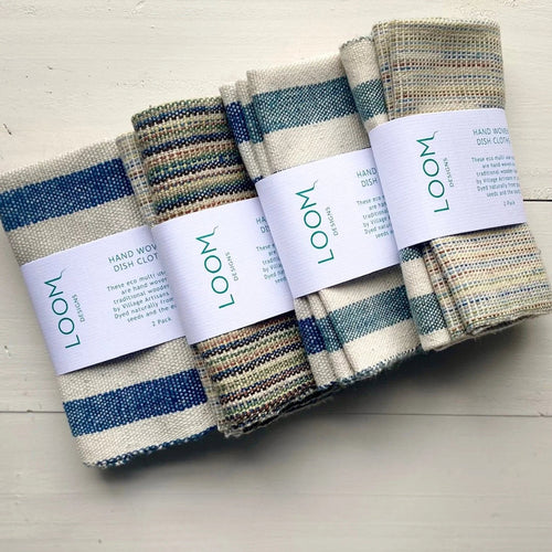 Set of striped dishcloths with 'LOOM' labels on a light wooden surface