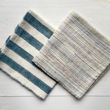 Load image into Gallery viewer, Two woven placemats with different patterns on a light wooden surface

