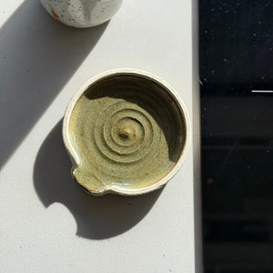 Small ceramic bowl with concentric circle pattern on a light surface