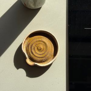 Two ceramic items on a flat surface with a light background