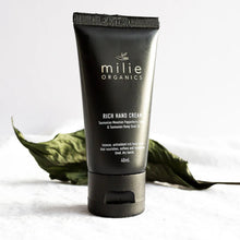 Load image into Gallery viewer, Black tube of milie Organics Rich Hand Cream with green leaves on a light background
