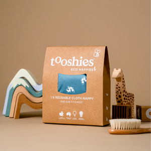 tooshies eco nappies packaging with reusable cloth nappy on a beige background