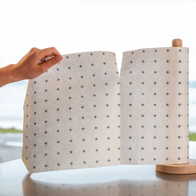 Load image into Gallery viewer, Roll of patterned paper held by a hand with a blurred outdoor background
