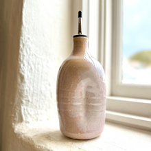 Load image into Gallery viewer, Ceramic bottle with a textured surface on a windowsill
