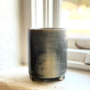 Black ceramic pot on a windowsill with natural light