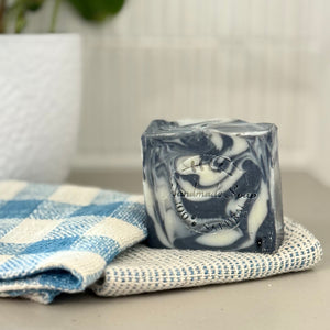 Marble-patterned soap bar on a checkered towel with a blurred background
