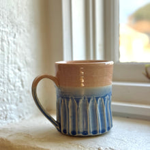 Load image into Gallery viewer, Ceramic mug with blue and beige design on a windowsill
