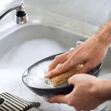 Load image into Gallery viewer, Person washing a frying pan with a sponge in a sink.
