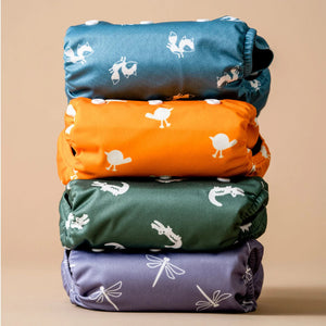 Stack of colorful fabric wraps with animal prints on a beige background