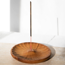 Load image into Gallery viewer, Incense stick on a wooden holder against a white wall
